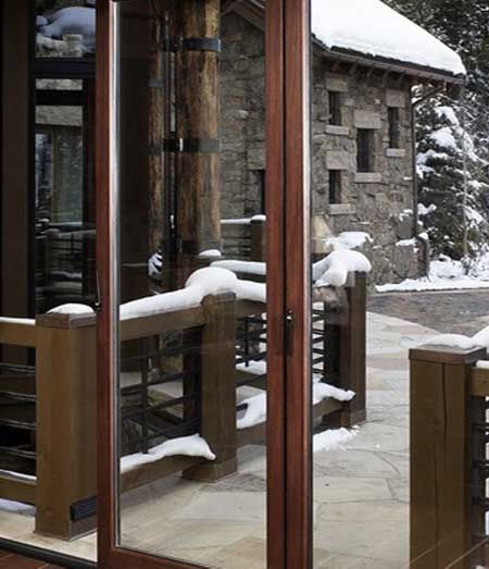 A close-up of a glass door with a snowy exterior background.