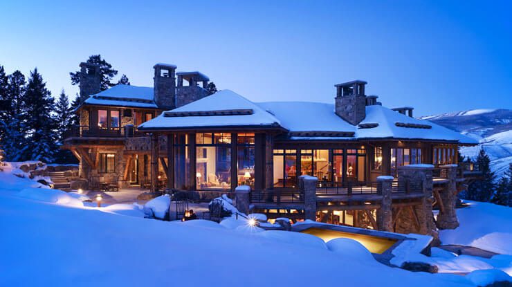 A full-shot of a house covered with snow on a snowy mountain slope. Private Residence at Tall Timber.